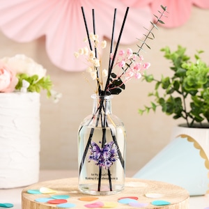 May include: A clear glass bottle diffuser with black reeds and a purple butterfly design. The bottle has a label that reads "For My Special Mom Thinking of you always, love you so".