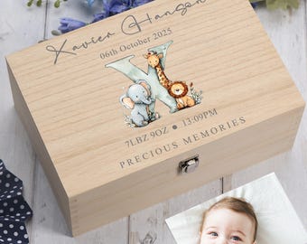 May include: A rectangular light-coloured wooden keepsake box featuring the name Xavier Hanson, the date 06th October 2025, the weight 7LBZ 9OZ, and the time 13:09PM. A large letter K is decorated with illustrations of a baby elephant, giraffe, and lion.