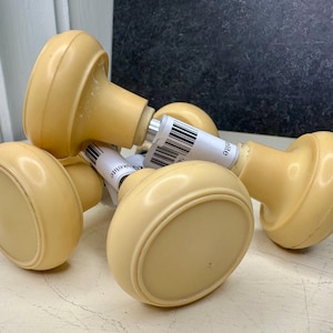 May include: A collection of vintage-style, cream-colored door knobs. Each knob has a rounded, oval shape with a cylindrical base. The knobs are made of a smooth, solid material and appear to be in good condition.