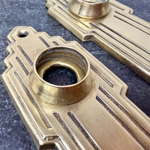 May include: A set of three ceramic mugs with a speckled, matte finish. The mugs are in shades of cream, light gray, and dark gray. Each mug has a simple, minimalist design and a rounded handle. Perfect for coffee or tea.