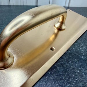 May include: A rustic wooden sign with the text "Welcome to our home" in white lettering. The sign features a distressed finish and a simple, inviting design, perfect for front door decor.