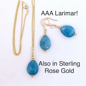 May include: A gold necklace and earrings set with teardrop-shaped blue Larimar stones. The text "AAA Larimar!" and "Also in Sterling Rose Gold" is visible in the image.