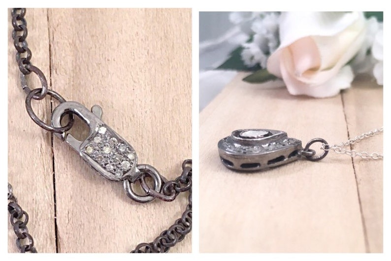 Puede incluir: Un collar de plata con un colgante en forma de l&aacute;grima con un peque&ntilde;o diamante en el centro. El colgante est&aacute; rodeado de diamantes m&aacute;s peque&ntilde;os y la cadena es de plata con un cierre de langosta.