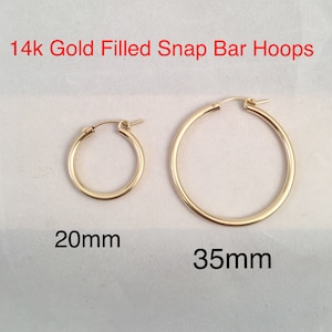 May include: Two pairs of 14k gold filled snap bar hoop earrings. The smaller pair is 20mm in diameter and the larger pair is 35mm in diameter.