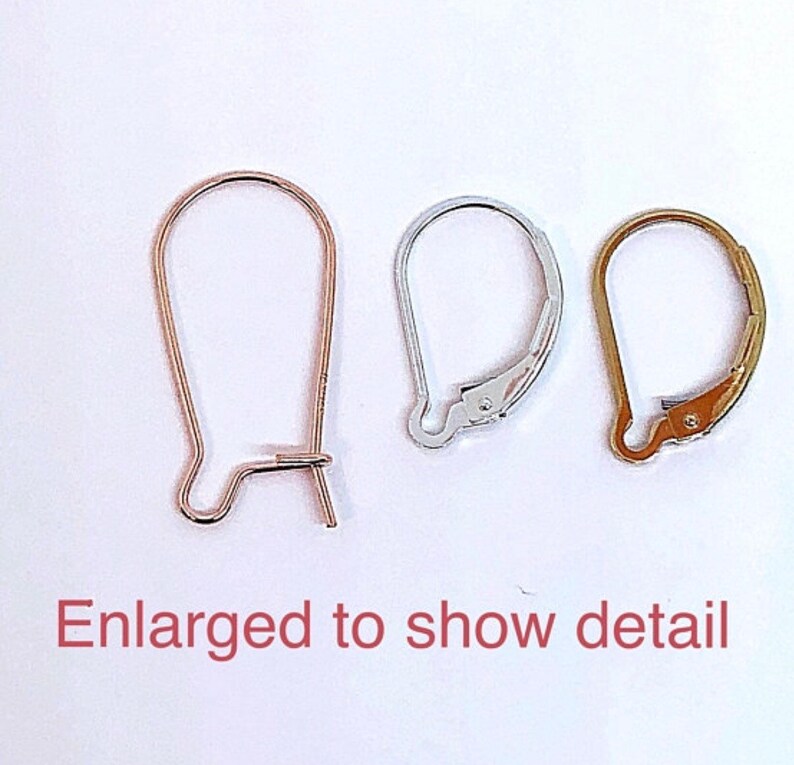 May include: Three earring hooks in different finishes: gold, silver, and rose gold. The hooks are enlarged to show detail.