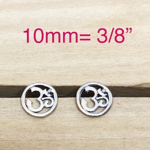 May include: Two silver charm pendants with an Om symbol design. Each pendant measures 10mm or 3/8 inches in diameter.