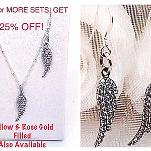 May include: A set of silver earrings and a necklace with a wing charm. The earrings and necklace are made of silver and have a sparkly finish. The text "BUY 3 or MORE SETS GET 25% OFF!" and "Yellow & Rose Gold Filled Also Available" is visible in the image.