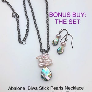 Könnte beinhalten: Eine Abalone Biwa Stick Perlen Halskette und Abalone Süßwasser Perlen Ohrringe. Die Halskette hat eine silberne Kette mit einem tropfenförmigen Abalone Muschel Anhänger und einem Cluster aus weißen Perlen. Die Ohrringe sind silber mit tropfenförmigen Abalone Muschel Anhängern und einer einzelnen weißen Perle.