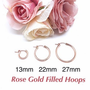 May include: Three rose gold filled hoop earrings in different sizes: 13mm, 22mm, and 27mm. Rose Gold Filled Hoops.