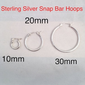 May include: Three sterling silver snap bar hoops in different sizes: 10mm, 20mm, and 30mm. The hoops are all silver and have a smooth finish.