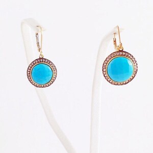 May include: A pair of gold earrings with turquoise stones and a diamond halo setting.