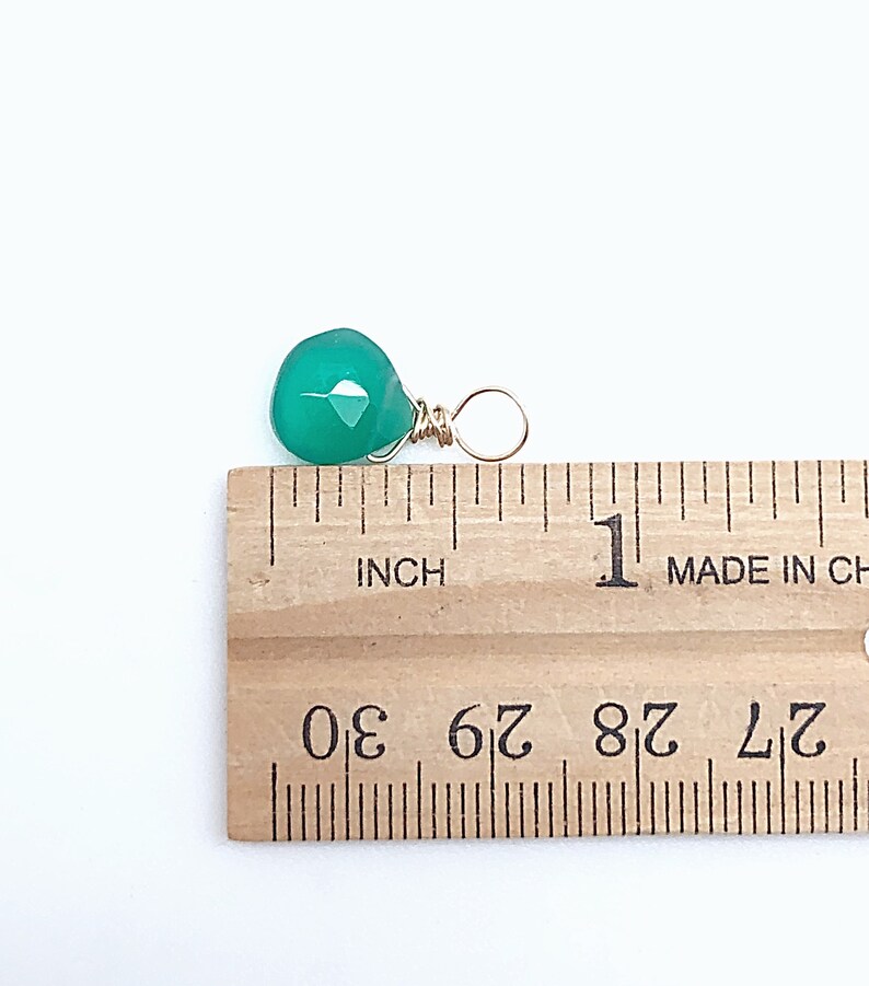 May include: A green gemstone pendant with a gold wire wrap. The pendant is approximately 1/2 inch in size.