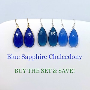 May include: Set of six teardrop-shaped earrings with blue chalcedony gemstones. The earrings are silver and gold toned. The earrings are displayed on a white surface.  Blue Sapphire Chalcedony. BUY THE SET & SAVE!