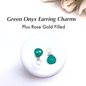 May include: Two green onyx earring charms with rose gold filled wire wraps. The charms are on a white surface.