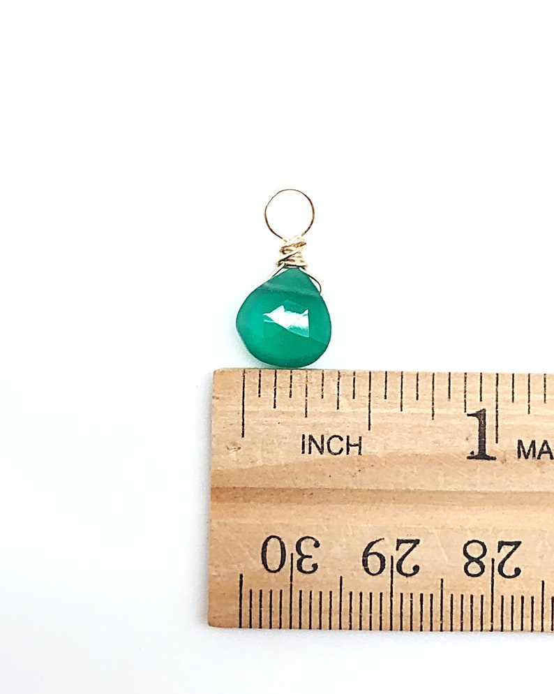 May include: A green gemstone pendant with a gold wire wrap. The pendant is approximately 1/2 inch in size.