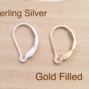 May include: Two earring backs, one sterling silver and one gold filled. The sterling silver earring back is on the left and the gold filled earring back is on the right.
