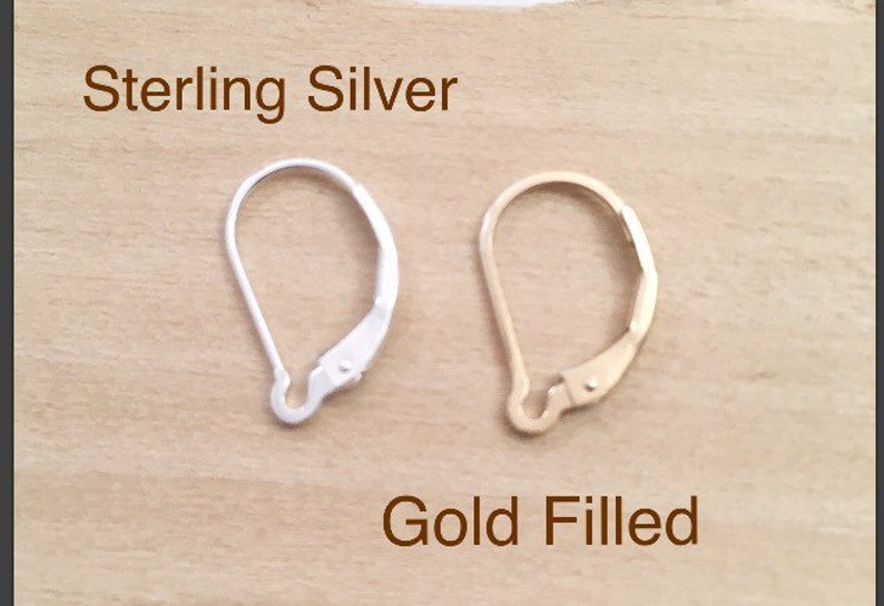 May include: Two earring backs, one sterling silver and one gold filled. The sterling silver earring back is on the left and the gold filled earring back is on the right.