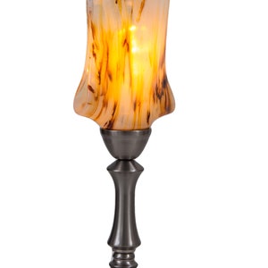 May include: A table lamp with a swirl-patterned glass shade in shades of brown and white. The lamp base is made of metal and has a brushed nickel finish.