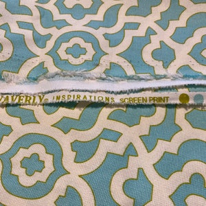 May include: White fabric with a blue and green geometric pattern. The fabric has a label that reads "Waverly Inspirations Screen Print".