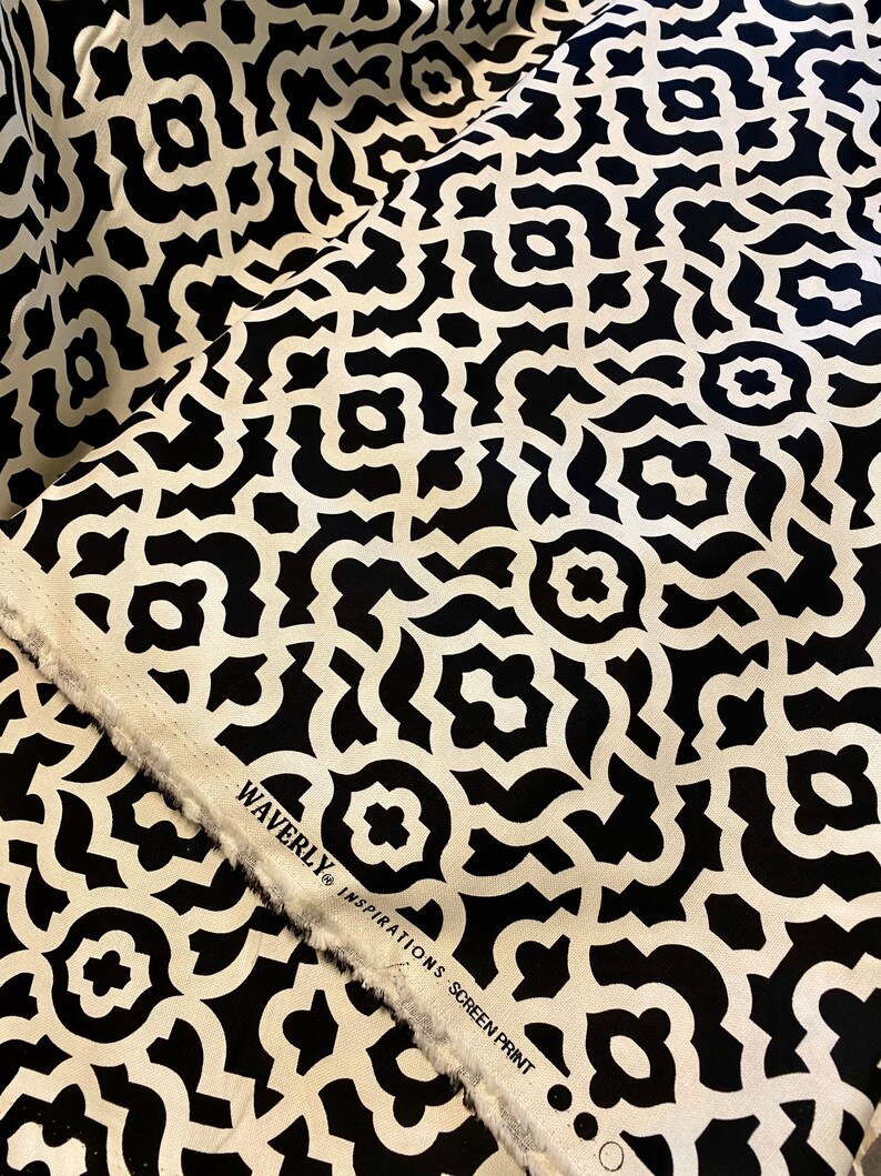May include: Black and white fabric with a geometric pattern. The fabric has the text "Waverly Inspirations Screen Print" on the edge.