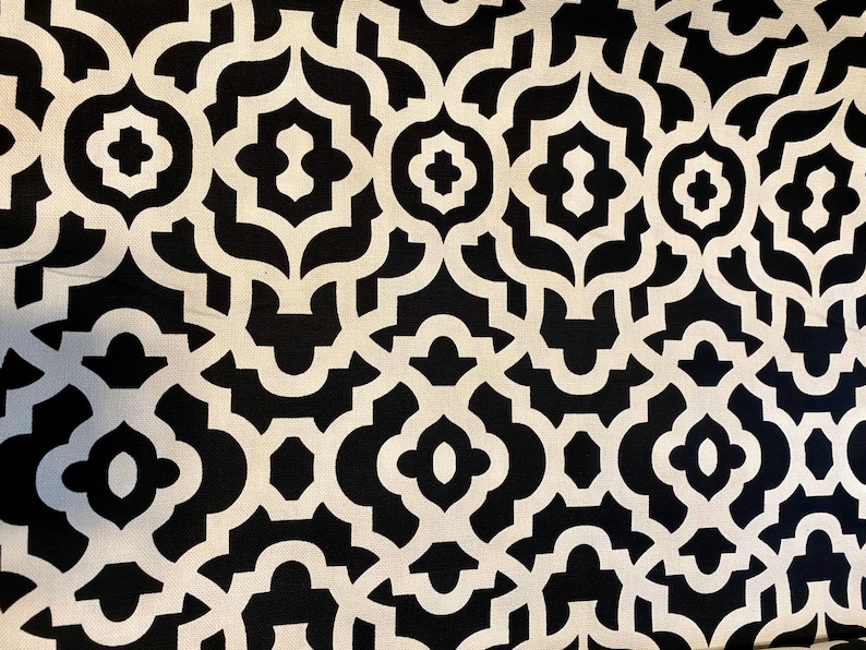 May include: Black and white geometric fabric with a repeating pattern of interlocking shapes. The fabric has a subtle sheen and a smooth texture.