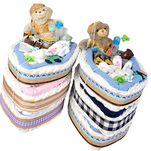 May include: Two diaper cakes, one in pink and one in blue, decorated with teddy bears, baby bottles, and other baby items.