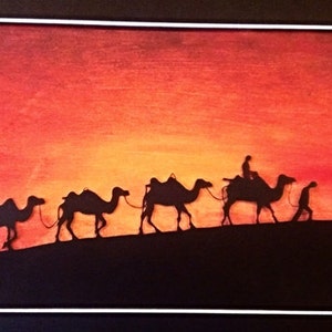 May include: Silhouette of a camel caravan against a vibrant orange and red sunset. The camels are walking in a line, with a person riding the lead camel. The image is painted in a watercolour style.