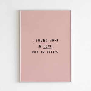 May include: A pink framed print with the text "I found home in love, not in cities."