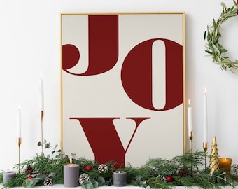 May include: A white fireplace mantel decorated with a green garland, gold candlesticks, and white candles. A framed print with the word "JOY" in red letters hangs above the mantel.