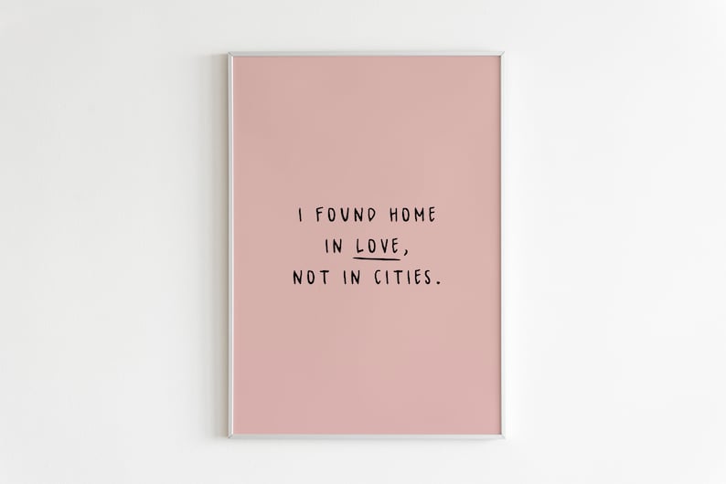 May include: A pink framed print with the text "I found home in love, not in cities."