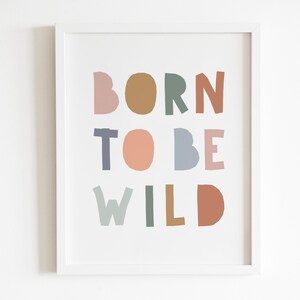 May include: A framed print with the text "BORN TO BE WILD" in colorful, stylized letters. The letters are in shades of pink, brown, green, blue, and orange.