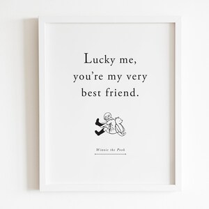 May include: A white framed print with a black and white illustration of Winnie the Pooh and Piglet. The text reads "Lucky me, you're my very best friend." and "Winnie the Pooh" at the bottom.