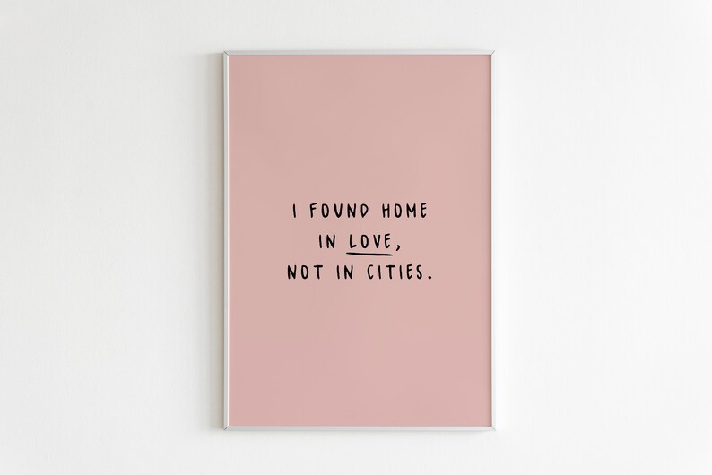 May include: A pink framed print with the text "I found home in love, not in cities."