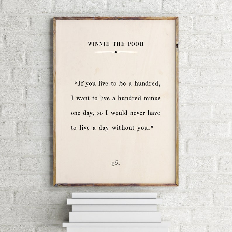 May include: A Winnie the Pooh quote print in a wooden frame. The quote reads, "If you live to be a hundred, I want to live a hundred minus one day, so I would never have to live a day without you." The print is numbered 95.