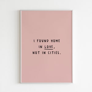 May include: A pink framed print with the text "I found home in love, not in cities."