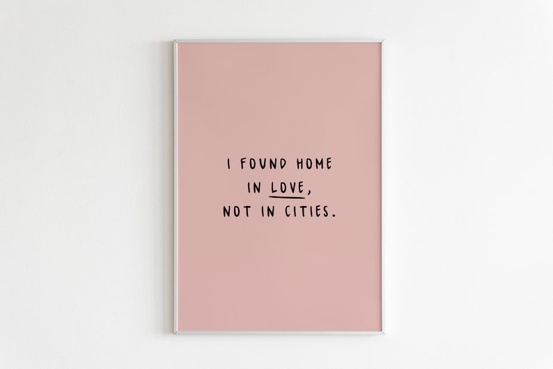 May include: A pink framed print with the text "I found home in love, not in cities."