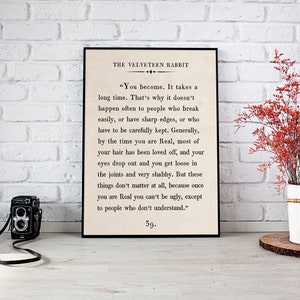 May include: A black framed print with a white background and black text. The text is an excerpt from the book "The Velveteen Rabbit" by Margery Williams. The text reads: "You become. It takes a long time. That's why it doesn't happen often to people who break easily, or have sharp edges, or who have to be carefully kept. Generally, by the time you are Real, most of your hair has been loved off, and your eyes drop out and you get loose in the joints and very shabby. But these things don't matter at all, because once you are Real you can't be ugly, except to people who don't understand." 59.