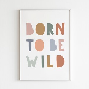 May include: A framed print with the text "BORN TO BE WILD" in colorful, cut-out letters. The letters are in shades of pink, brown, green, blue, and orange.