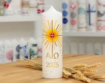 May include: A white candle with a gold and red design of a sun with a cross inside. The candle has the text "AΩ 2025" on it.