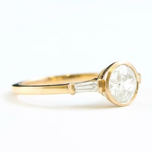 Moissanite and diamond engagement ring handmade in yellow gold with baguette accent stones