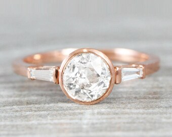 White sapphire and diamond engagement ring handmade in rose gold with baguette accent stones