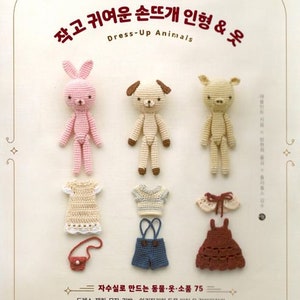 May include: A crochet pattern book featuring a pink bunny, a brown dog, and a brown pig wearing crocheted outfits. The book title is "Small and Cute Crochet Dolls & Clothes" in Korean. The book cover also includes the text "Dress-Up Animals".