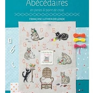 May include: A book cover with the title "Abécédaires" and the subtitle "en perles & point de croix". The cover features a teal background and a cross-stitch sampler with cats, letters, and decorative elements. The author's name is "FRANCOISE LUTHIER-DIEUZAIDE".