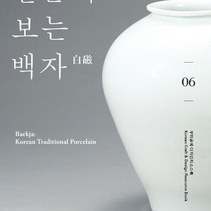 May include: A white porcelain vase with a rounded body and a wide mouth. The vase is sitting on a grey background. The text "Baekja: Korean Traditional Porcelain" is written below the vase.