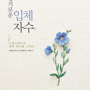 May include: A book cover with Korean text and a floral embroidery design. The title reads "Embroidered Flowers and Herbs" in Korean. A blue flower with green leaves is embroidered on the cover.