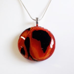 Cast glass pendant in red, orange and black glass.