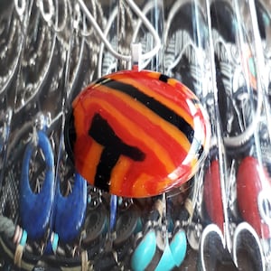Cast glass pendant, in red, orange and black.
