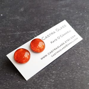 Stud earrings for pierced ears in orange dichroic glass.