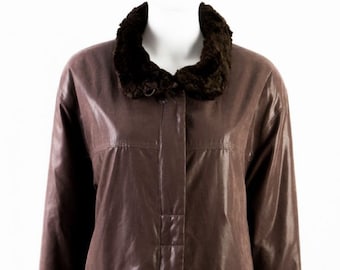 May include: A brown faux leather jacket with a fur collar and cuffs. The jacket has a zipper closure and two pockets.