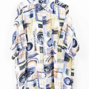 以下が含まれることがあります： 青、ベージュ、白の抽象的なパターンが施された半袖ボタンダウンシャツ。 シャツは襟付きで、胸ポケットが1つ付いています。 デザインには、幾何学的な形状と筆致のような要素が含まれています。